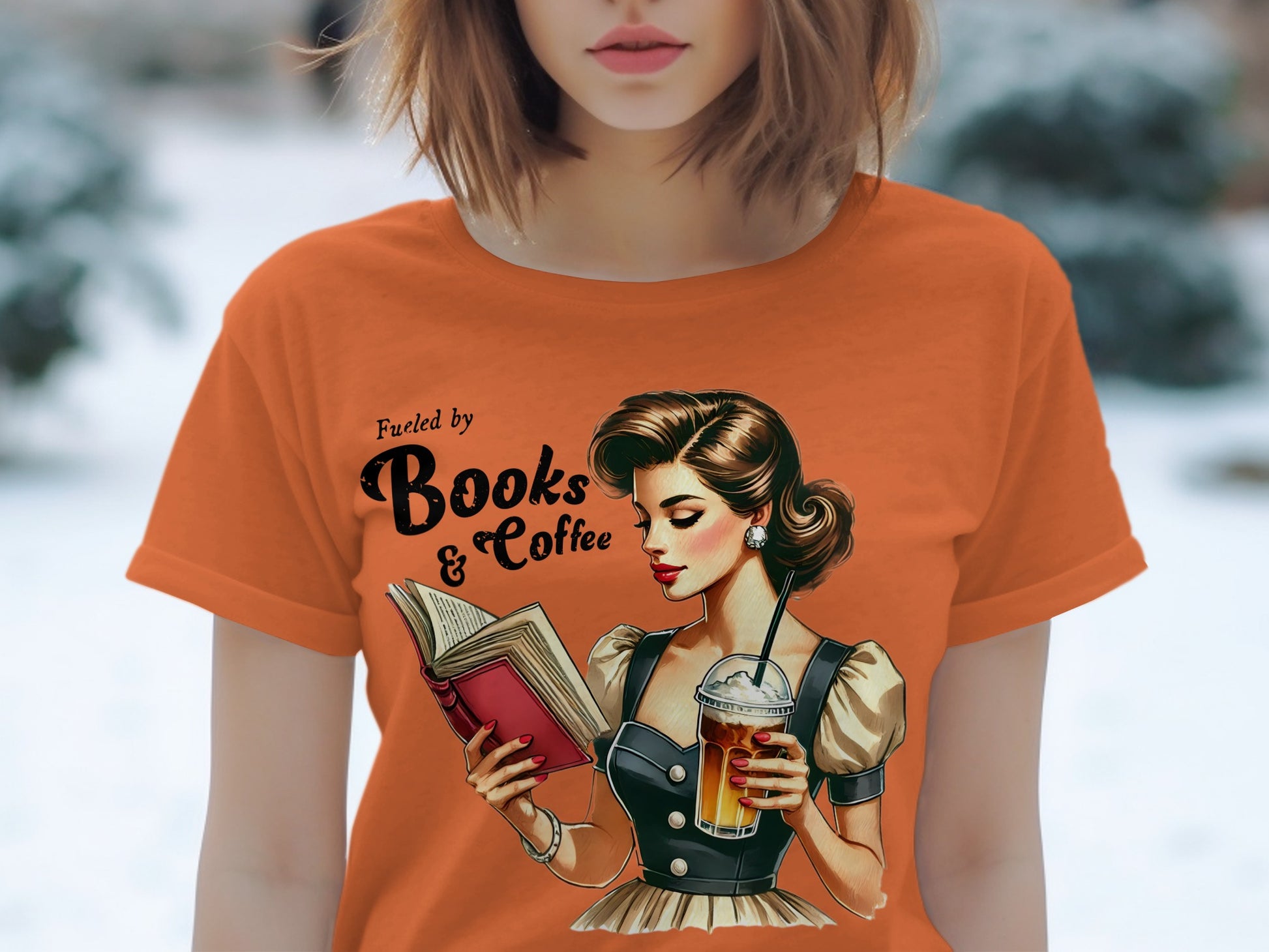 Orange t-shirt with "Fueled by Books & Coffee" and retro illustration of a woman reading.