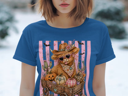 Cow with sunglasses in wagon full of pumpkins, bats, and cacti on striped background.