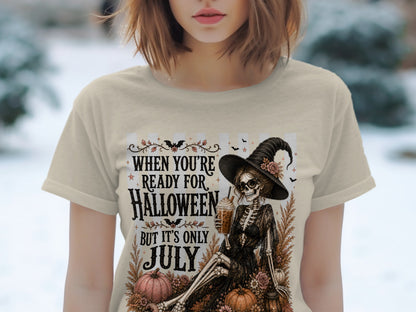 Skeleton wearing witch hat and sunglasses, holding iced coffee, with pumpkins and text.