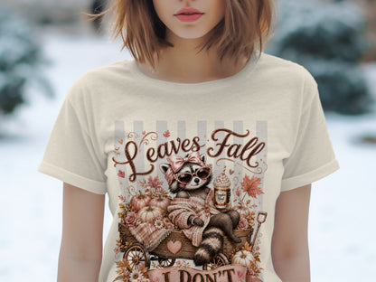 Raccoon in wagon with pumpkins, holding coffee, "Leaves Fall" text.