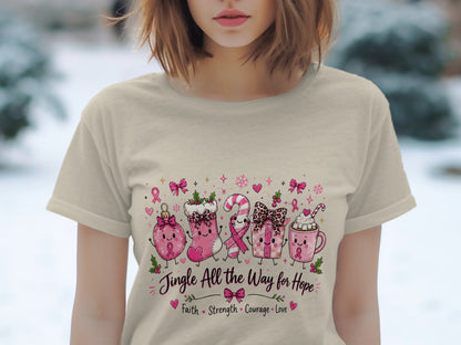 Pink Christmas characters and text "Jingle All the Way for Hope" on a tan t-shirt.