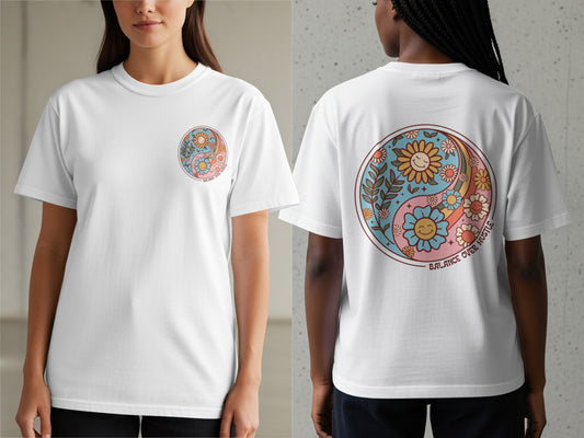White t-shirt with a retro yin yang design featuring smiling flowers and the text "BALANCE OVER HUSTLE".