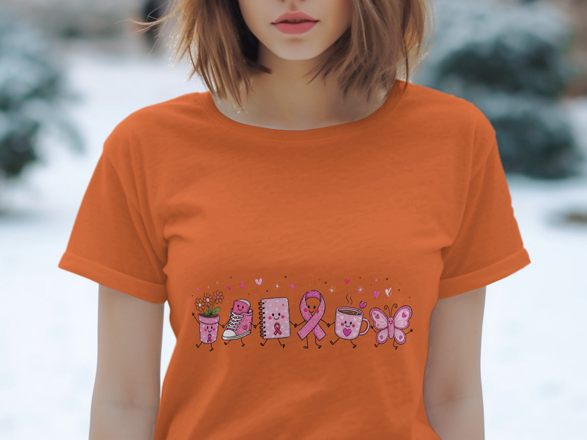 Orange t-shirt with cartoon drawing of breast cancer awareness ribbon, coffee mug, butterfly, and more.
