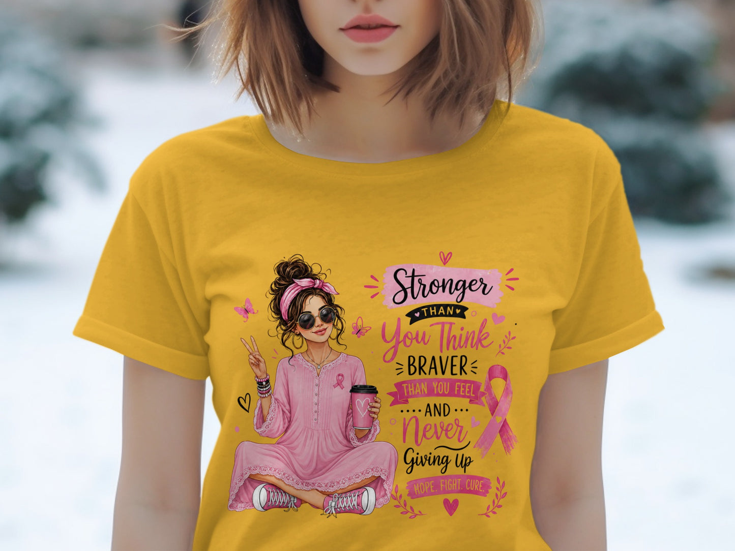Woman in yellow shirt with breast cancer ribbon graphic reading "Stronger Than You Think..."