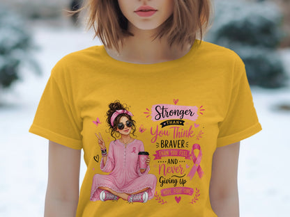 Woman in yellow shirt with breast cancer ribbon graphic reading "Stronger Than You Think..."