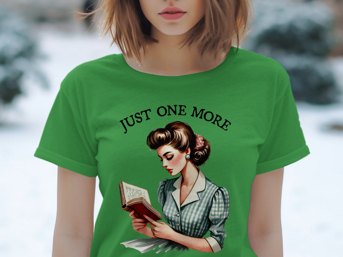 Green t-shirt with "JUST ONE MORE" text and retro woman reading a book graphic.