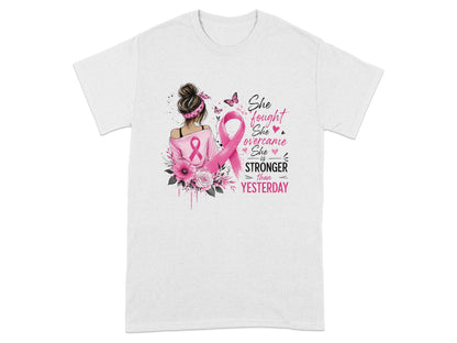 T-shirt with artwork of woman, pink ribbon, flowers, and text "She fought, she overcame, she is stronger than yesterday."