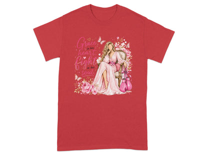 Red t-shirt with graphic of woman in pink dress, pink boxing gloves, flowers, and butterflies. Text: "Grace in her heart, fight in her soul."