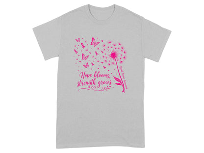 Gray t-shirt with pink dandelion, butterflies, ribbons, and text "Hope blooms, strength grows."