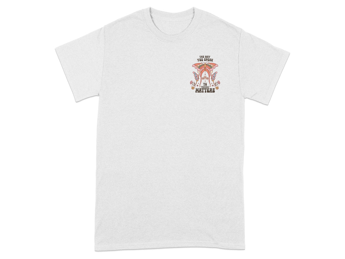 White t-shirt with a graphic of a butterfly and flowers that reads "the way you speak to yourself matters."