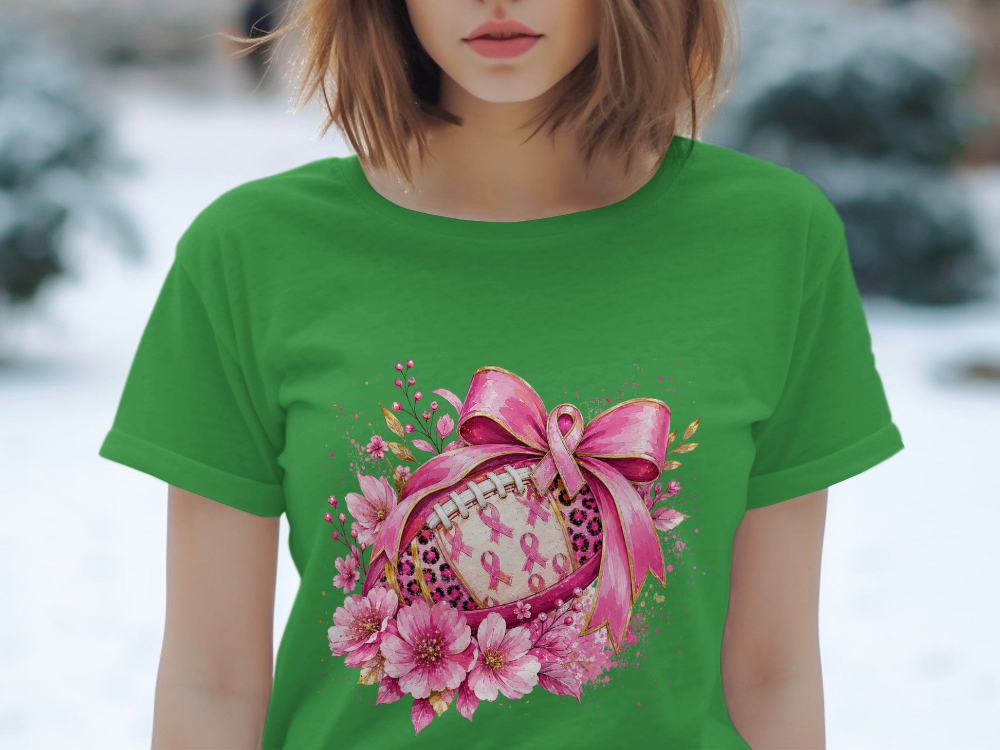 Green t-shirt with a football design featuring pink ribbons, leopard print, and flowers.