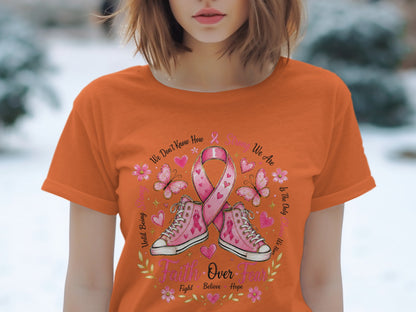 Orange t-shirt with pink ribbon, sneakers, butterflies, flowers, and text "Faith Over Fear".