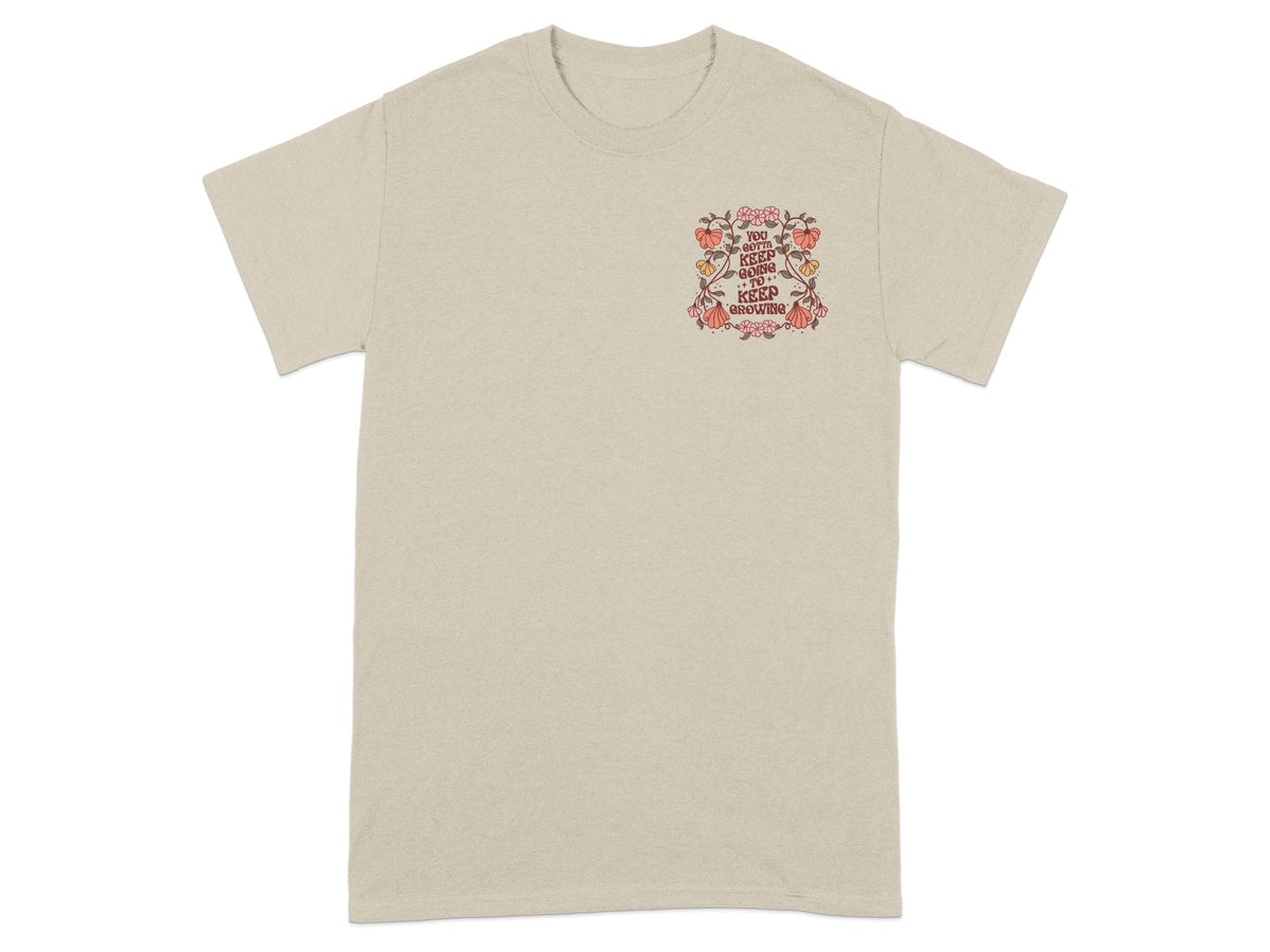 Beige t-shirt with a floral graphic and text "YOU GOTTA KEEP GOING TO KEEP GROWING".