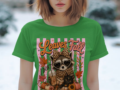 Graphic t-shirt design features a raccoon and cat with "Leaves Fall I Don't".
