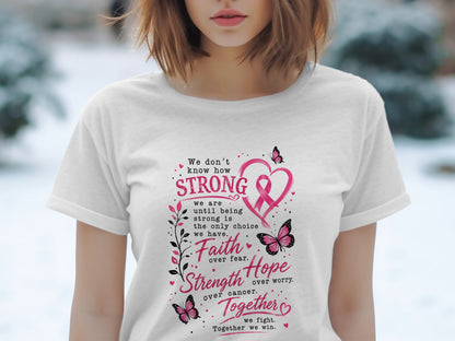 White t-shirt with pink text and butterflies: "We don't know how STRONG... Faith over fear. Strength over cancer. Together we fight."