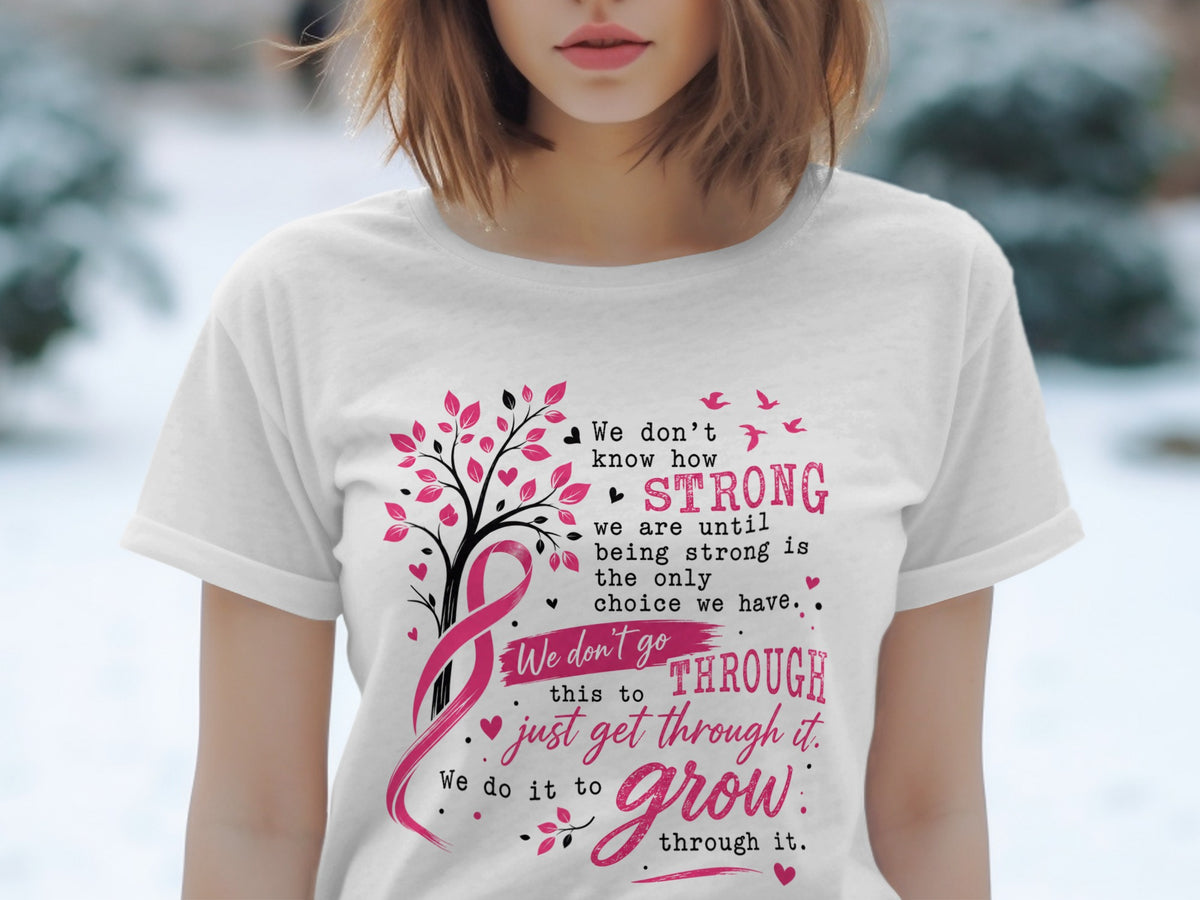 White t-shirt with breast cancer awareness ribbon and inspiring text about strength and growth.