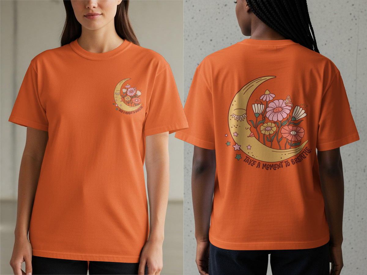 Orange t-shirt with celestial moon and flowers graphic that says "take a moment to breathe."
