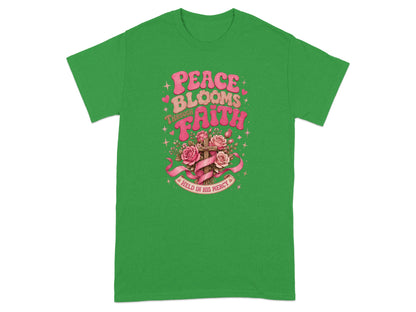 Green t-shirt with "Peace Blooms Through Faith" text and floral cross.