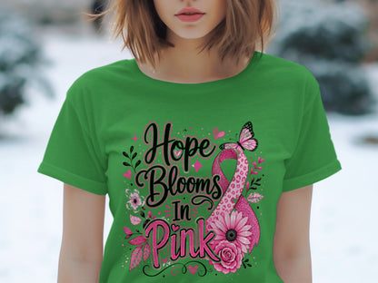 Green t-shirt with "Hope Blooms In Pink" text and pink ribbon design.