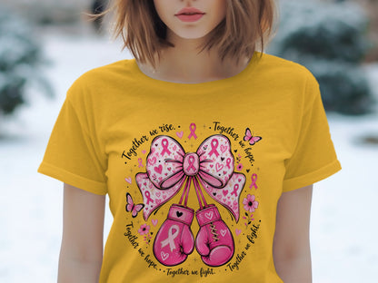 Yellow t-shirt with pink boxing gloves, ribbons, butterflies, flowers, and text "Together we rise. Together we hope. Together we fight."