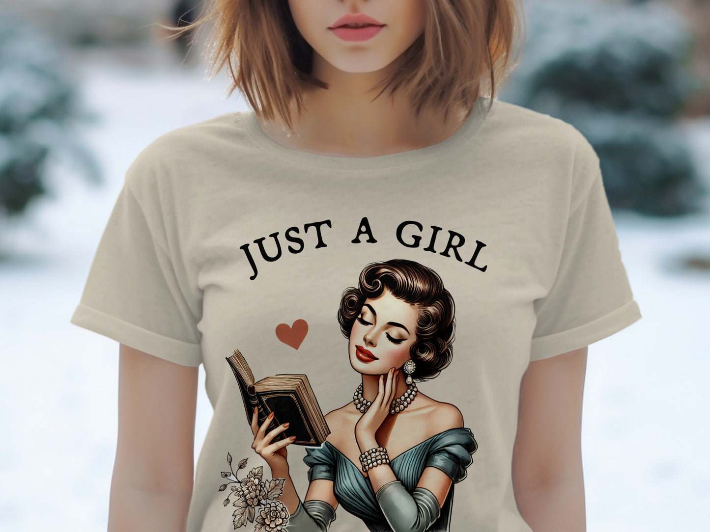 T-shirt with "JUST A GIRL" text and illustration of woman reading a book.