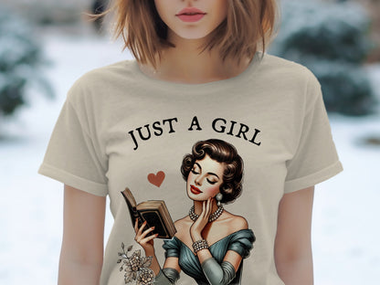 T-shirt with "JUST A GIRL" text and illustration of woman reading a book.