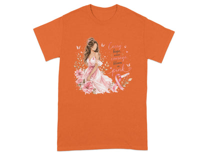 Orange t-shirt with a woman surrounded by flowers and the text "Carry hope, wear courage, bloom in pink."