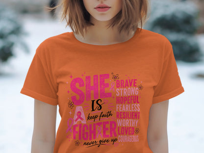 Orange t-shirt with "She is a fighter" text and motivational words.