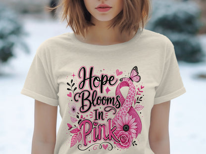 Light pink t-shirt with "Hope Blooms In Pink" text and breast cancer ribbon design.