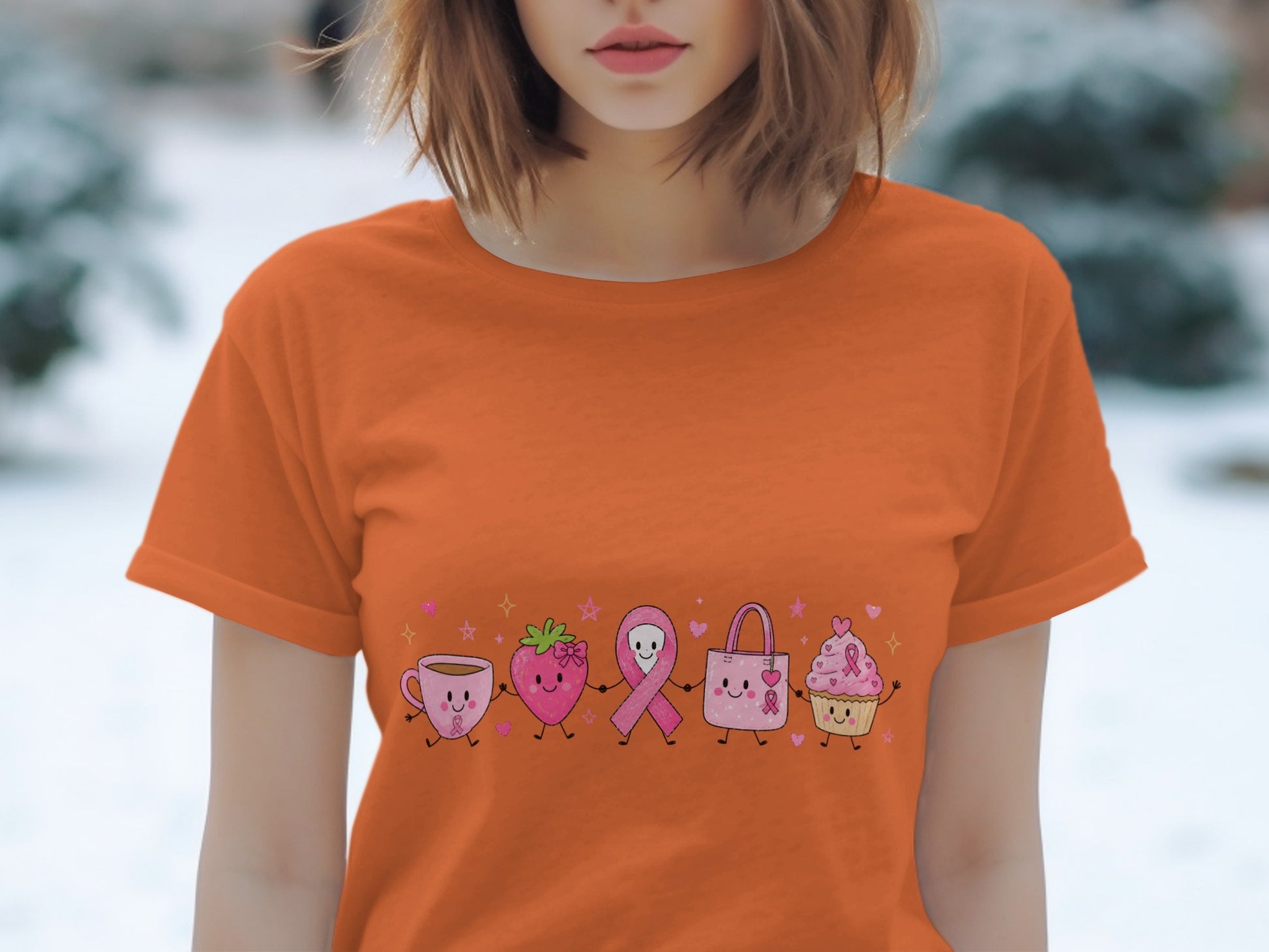 Orange t-shirt with cartoon coffee cup, strawberry, ribbon, bag, and cupcake characters.