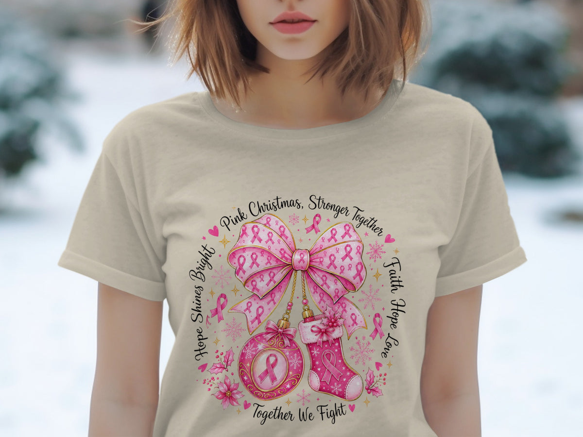 T-shirt with pink Christmas design, bow, ornament, stocking, and cancer ribbons.