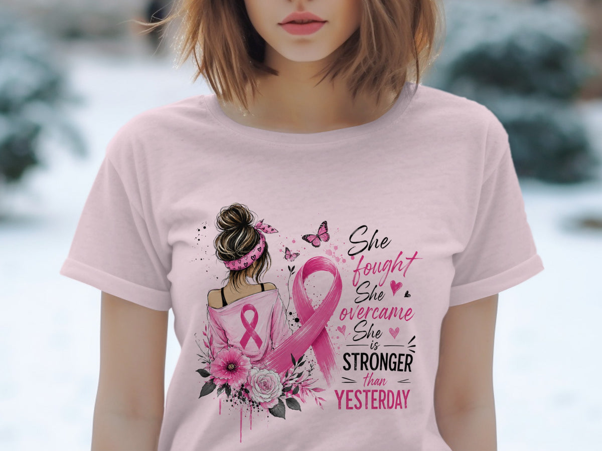 Pink t-shirt with breast cancer awareness ribbon and quote: "She fought, she overcame, she is stronger than yesterday."