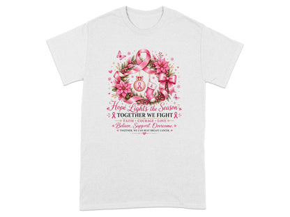 White t-shirt with wreath graphic featuring pink ribbons and text about breast cancer awareness.